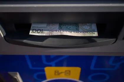 Banknotes emerging from a cash machine — the experience Jamaican searchers expect from a Bitcoin ATM, and cannot get locally