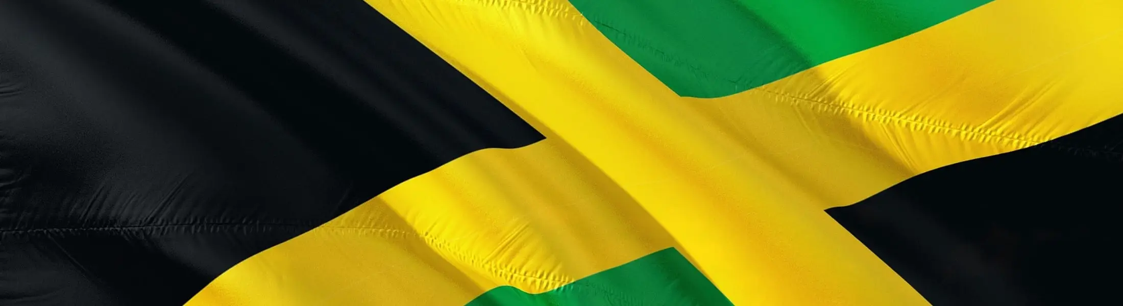 The Jamaican flag flying against a clear sky