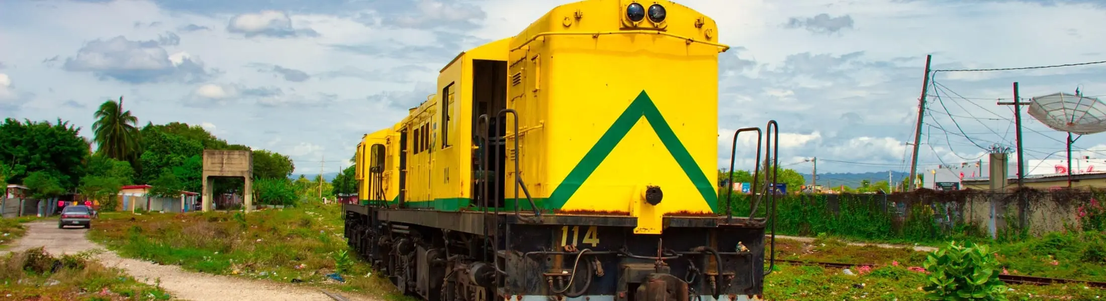 A disused Jamaica Railway locomotive standing on overgrown track