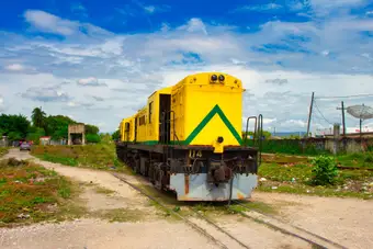 A disused Jamaica Railway locomotive on overgrown track — the country's inland transport gap in one image